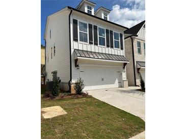 Charming two-story home featuring white siding, black shutters, and a convenient two-car garage at 1250 Winterhaven Dr, Cumming, GA 30041
