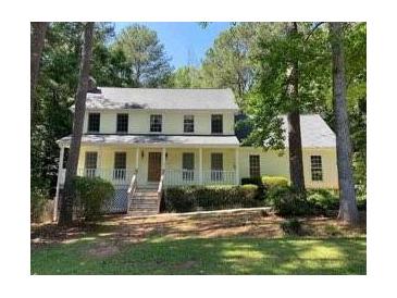 Inviting two-story home with a charming front porch and well-manicured lawn surrounded by mature trees at 340 Sherwood Se Cir, Conyers, GA 30094