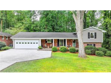 Charming home featuring a brick facade, a two-car garage, and a well-maintained landscaped yard at 595 Glenforest Rd, Sandy Springs, GA 30328