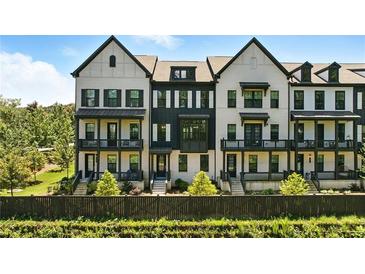 View of luxury townhomes with black framed windows, painted brick and beautifully manicured landscaping at 908 Catamaran Ct, Alpharetta, GA 30005