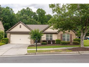 Charming single-story home with brick accents, mature landscaping, and a two-car garage at 1889 Raegan Way, Lawrenceville, GA 30043