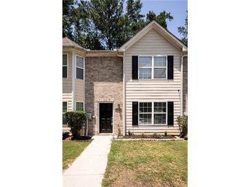 Charming townhome featuring a brick facade, black shutters, and well-maintained landscaping at 5538 Pineridge Ct, Forest Park, GA 30297