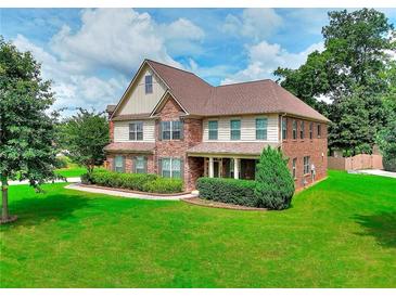 Attractive brick and siding two-story home with a well-maintained lawn and manicured landscaping at 2458 Brook Park Trl, Snellville, GA 30078