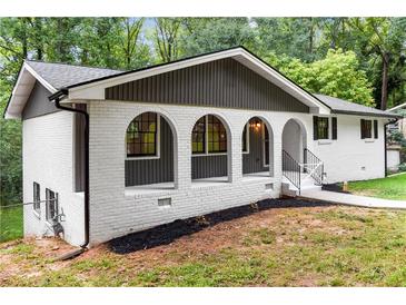 Charming home featuring a light-colored brick facade and lovely arched entryway at 3530 Turner Heights Dr, Decatur, GA 30032