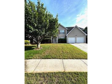 Traditional two-story home with a well-manicured lawn and a two-car garage at 7178 Glaspie Way, Atlanta, GA 30349