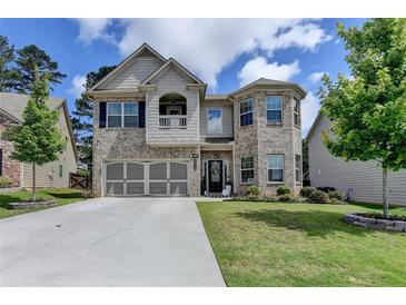 Beautiful two-story brick home with a well-manicured lawn and attached two-car garage at 2410 Melton Common Dr, Dacula, GA 30019