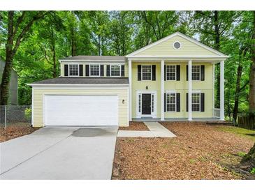 Charming two-story home with a two-car garage and a welcoming front porch surrounded by lush greenery at 1386 Heritage Glen Dr, Marietta, GA 30068