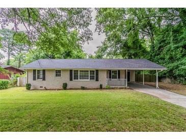 Charming brick home with a well-manicured front yard, carport, and cozy front porch at 2839 Long Way, Decatur, GA 30032