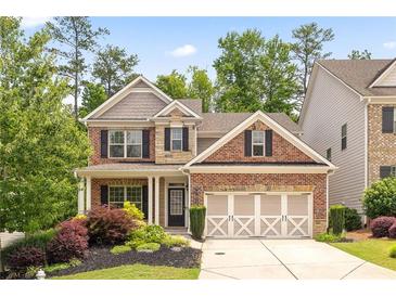 Charming brick two-story home with manicured landscaping and a three-car garage at 1220 Roswell Manor Cir, Roswell, GA 30076