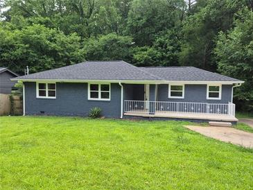 Charming single-story home with freshly painted blue exterior, new roof, and a well-manicured lawn at 2217 Sargent Se Pl, Atlanta, GA 30315