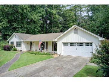 Charming single-story home with white siding, a well-manicured lawn, and an attached two-car garage at 2440 Weatherford Ct, Marietta, GA 30068