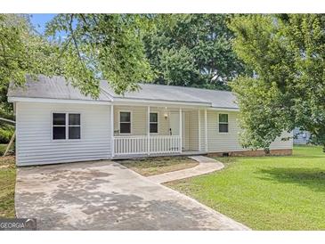 Charming single-story home with a covered front porch and a well-manicured lawn at 33 Russell Rd, Mcdonough, GA 30252