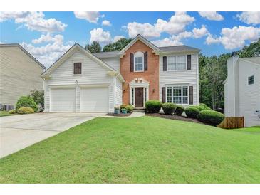 Charming two-story home with a well-manicured lawn, brick accents and an attached two-car garage at 3845 Lake Lanier Dr, Duluth, GA 30097