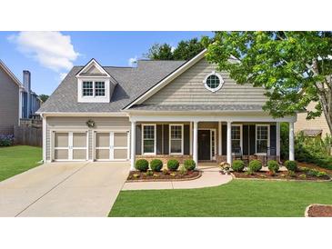 Charming home with a two-car garage, covered porch, well-manicured lawn, and mature landscaping at 100 Inspiration Ln, Dallas, GA 30157