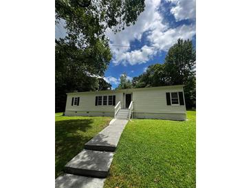 Well-maintained single-story home with a tidy front lawn and inviting entrance at 6830 Pawnee Trl Se, Acworth, GA 30102