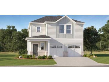 Charming two-story home with gray siding, double garage, and landscaped front yard at 2472 Cotton Ln, Douglasville, GA 30135