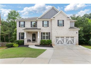 Charming two-story home with a brick facade, manicured lawn, and a two-car garage at 2307 Loughridge Dr, Buford, GA 30519
