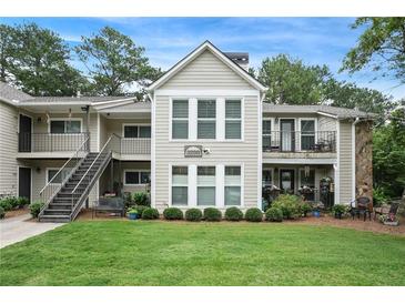Inviting condo featuring well-maintained landscaping, a combination of siding and stone, and a large front lawn at 3210 Lake Pointe Cir, Roswell, GA 30075