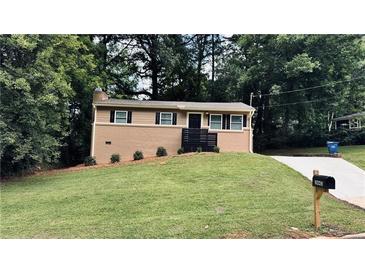 Charming ranch-style home featuring a brick facade, complemented by a well-manicured lawn and mature trees at 2443 Abner Nw Pl, Atlanta, GA 30318