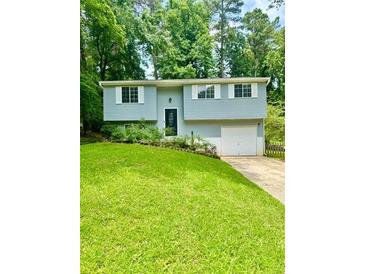 Charming home featuring a well-manicured lawn, light blue siding, and white garage door at 3544 Citrus Dr, Duluth, GA 30096