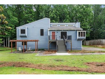 Charming blue two-story home with a wooden pergola and lush green yard at 2311 Sims Ne Dr, Marietta, GA 30066
