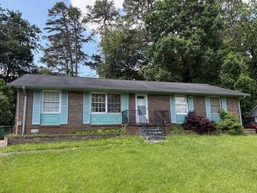 Charming single-story home with brick facade, light blue shutters, and well-maintained front yard at 1487 Colony East Cir, Stone Mountain, GA 30083