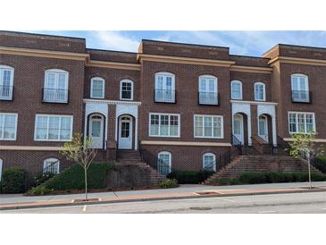 Charming brick townhomes with white trim and arched doorways, offering a classic and inviting facade at 5139 Peachtree Road, Chamblee, GA 30341