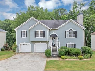 Charming two-story home with a two-car garage and well-manicured lawn and front yard at 1735 Silver Way, Lithia Springs, GA 30122