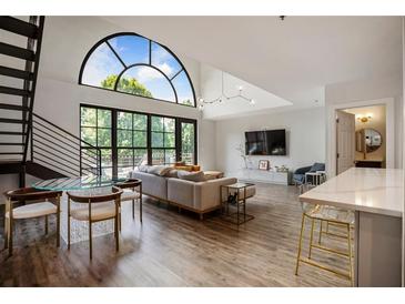 Bright living room featuring a modern sofa, elegant lighting, and an impressive arched window with views at 790 North Ne Ave # 209, Atlanta, GA 30306