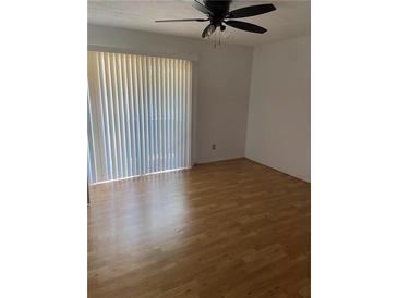 Bright bedroom with wood floor, ceiling fan and large window with vertical blinds at 1867 Myrtle Dr # 5, Atlanta, GA 30311