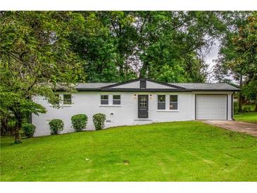 Charming single-story home with white painted brick and well-manicured lawn at 5961 John St, Austell, GA 30106