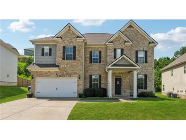 Charming two-story brick home featuring a well-manicured lawn and attached two car garage at 3711 Wartrace Dr, Atlanta, GA 30331