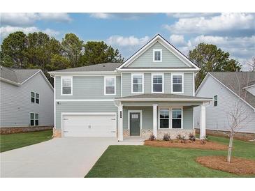 Charming two-story home featuring a two-car garage, covered porch, and manicured lawn at 251 Arnewood Cir, Mcdonough, GA 30253