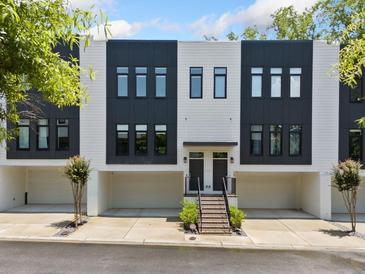 Modern townhome with black and white facade, two stories, private garages, and landscaped entry at 1103 Briar Cove Ne Cir, Atlanta, GA 30329