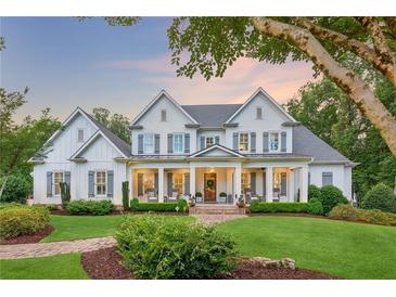 Stunning two-story home with white siding, shutters, manicured lawn, and inviting front porch at 150 Trinity Farm Dr, Canton, GA 30115