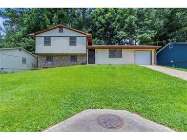 Charming split-level home with well-manicured lawn, stone accents, and attached garage in a desirable neighborhood at 2247 Cherokee Valley Dr, Lithonia, GA 30058