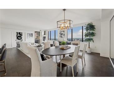 Bright and airy dining room with modern chandelier and floor-to-ceiling windows offering stunning city views at 75 14Th Ne St # 3820, Atlanta, GA 30309