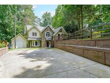 Charming home featuring unique stone accents, a spacious driveway, and lush greenery at 835 Timber Lake Trl, Cumming, GA 30041