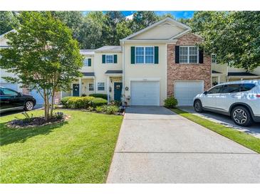Charming townhome with a well-manicured front yard, driveway, and attached garage at 183 Venture Path, Hiram, GA 30141