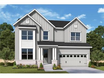Charming two-story home with a brick foundation, light gray siding, and a two-car garage at 202 Wild Ginger Bnd, Woodstock, GA 30188