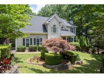 Charming home with manicured lawn, mature trees, and meticulously maintained landscaping at 3511 Stone Cliff Way, Woodstock, GA 30189