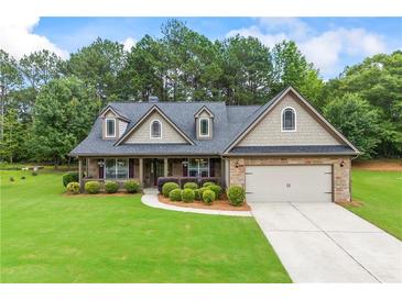 Charming home with stone and siding exterior, well-manicured lawn, and attached two-car garage at 1524 Guthrie Crossing Dr, Loganville, GA 30052