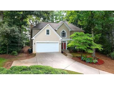 Charming two-story home with well-manicured landscaping and an attached two-car garage at 140 Ashewoode Downs Ln, Johns Creek, GA 30005