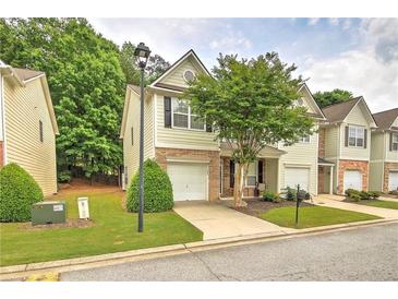 Charming townhome features a well-manicured lawn, a one-car garage, and inviting curb appeal at 1643 Jackson Nw Way, Atlanta, GA 30318