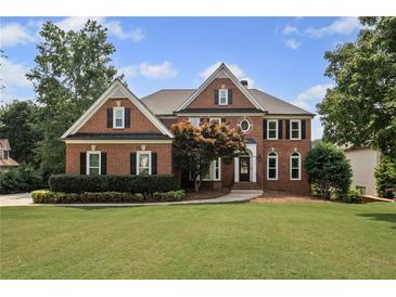 Beautiful brick two-story home featuring manicured lawn and mature trees at 390 Wilde Green Dr, Roswell, GA 30075