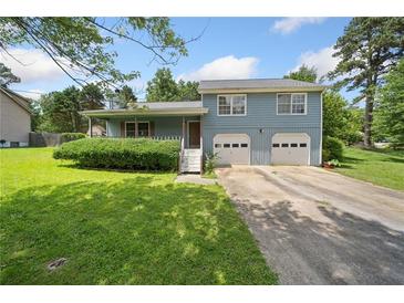 Charming two-story home with a well-manicured lawn and a two-car garage at 58 6Th W Ave, Dallas, GA 30157
