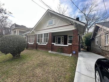 Charming brick home with covered front porch and landscaped front yard at 472 Parkway Ne Dr, Atlanta, GA 30308