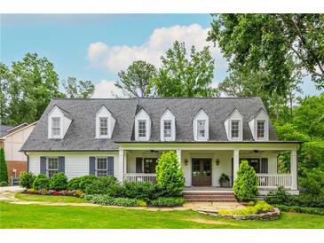 Charming home featuring a welcoming front porch, dormer windows, manicured lawn, and mature landscaping, creating inviting curb appeal at 505 Junction Pt, Roswell, GA 30075