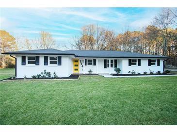 Charming single story home featuring a new roof, landscaping and bright yellow front door at 144 Morning Creek Rd, Jonesboro, GA 30238