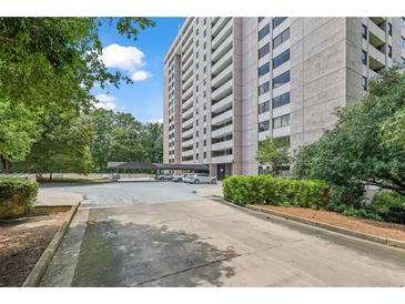 View of building exterior showing a covered parking area with well-maintained landscaping and manicured bushes at 3530 Piedmont Ne Rd # K8, Atlanta, GA 30305